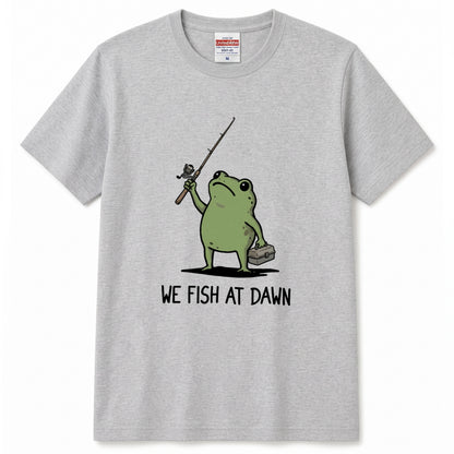 「WE FISH AT DAWN」タックルボックスとカエルTシャツ