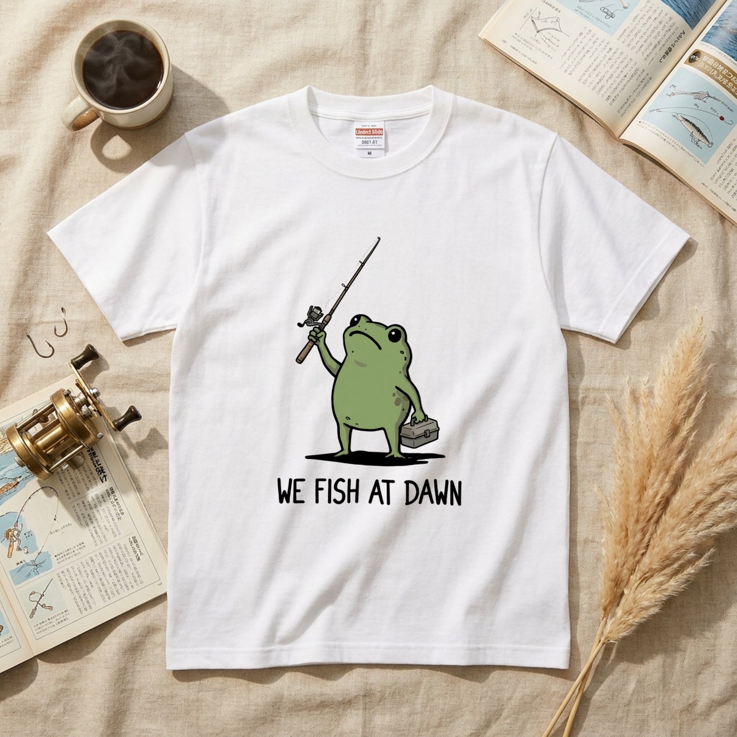 「WE FISH AT DAWN」タックルボックス持つ蛙 ゆるカワ白Tシャツ | CASTMODE